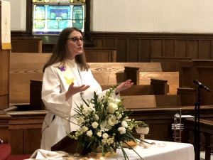 Rev. Jenny Smith Walz preaches with arms outstretched